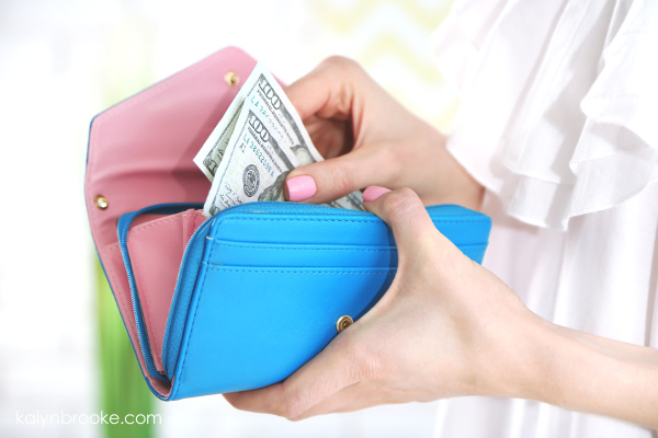 woman pulling cash from her wallet