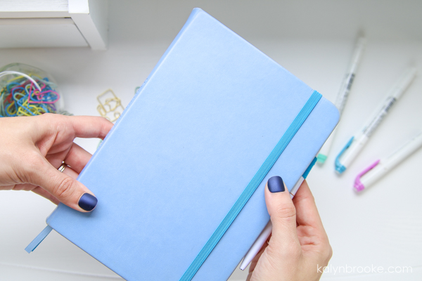 woman holding a blue notebook